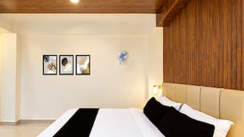 Un dormitorio moderno con una cama grande, cabecera de madera y tres obras de arte enmarcadas en la pared.