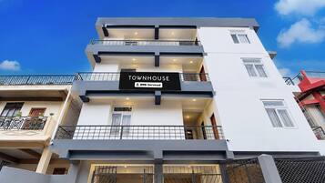 A multi-story building with a sign indicating it is serviced by OYO.