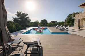 Ein Swimmingpool mit Liegestühlen und Sonnenschirm.