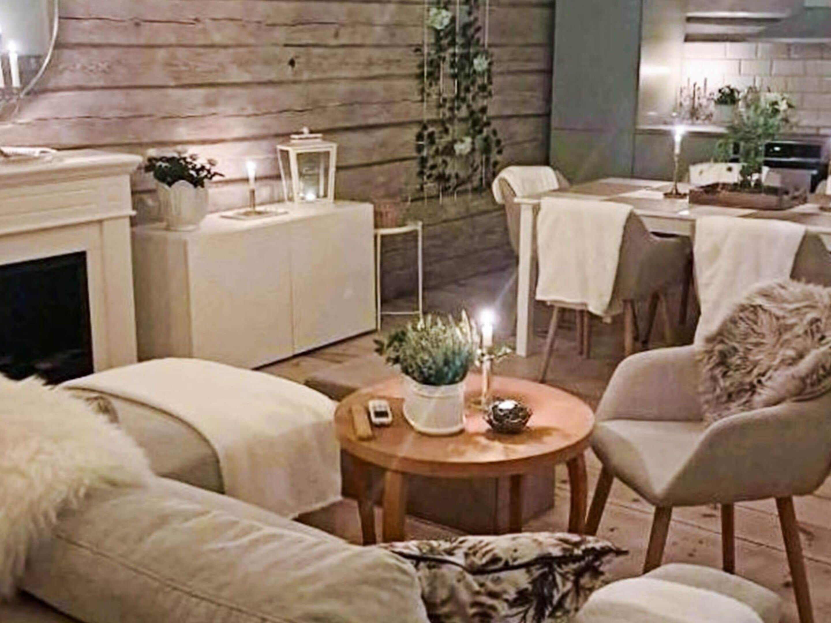 Un accogliente soggiorno con camino, una zona pranzo con tavolo e sedie, e un piccolo tavolino con oggetti decorativi.