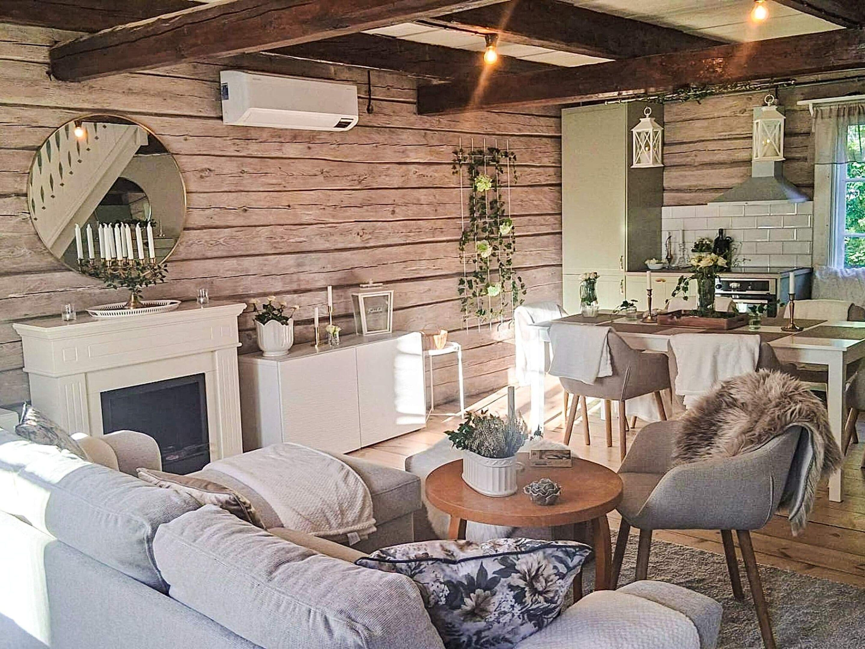 A cozy living room with a fireplace, a dining area, and a kitchen.