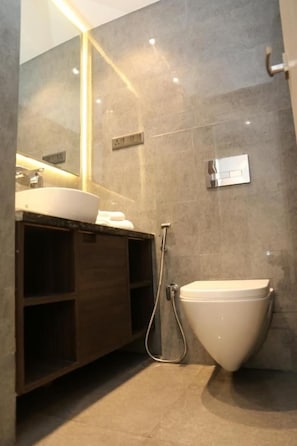 Un baño moderno con tocador, lavamanos e inodoro.