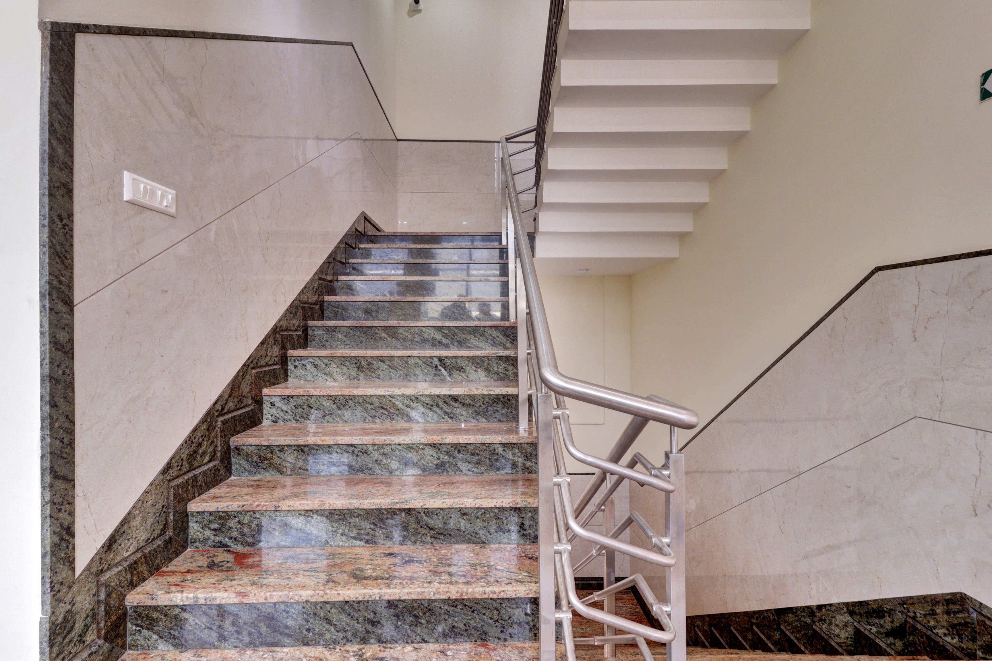 A staircase with marble steps and metal handrails.