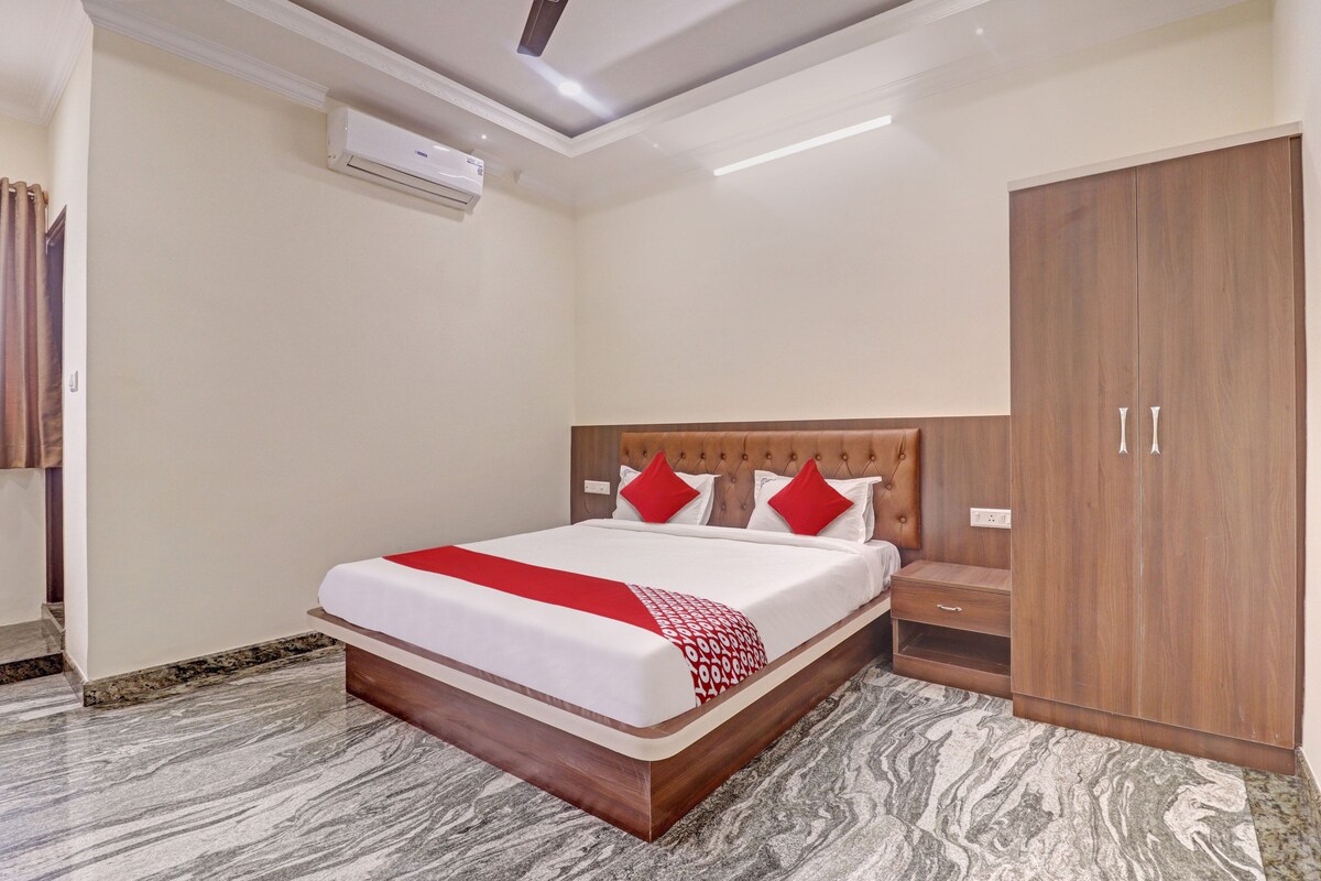 Habitació d'hotel amb un llit, un armari i un aparell d'aire condicionat.