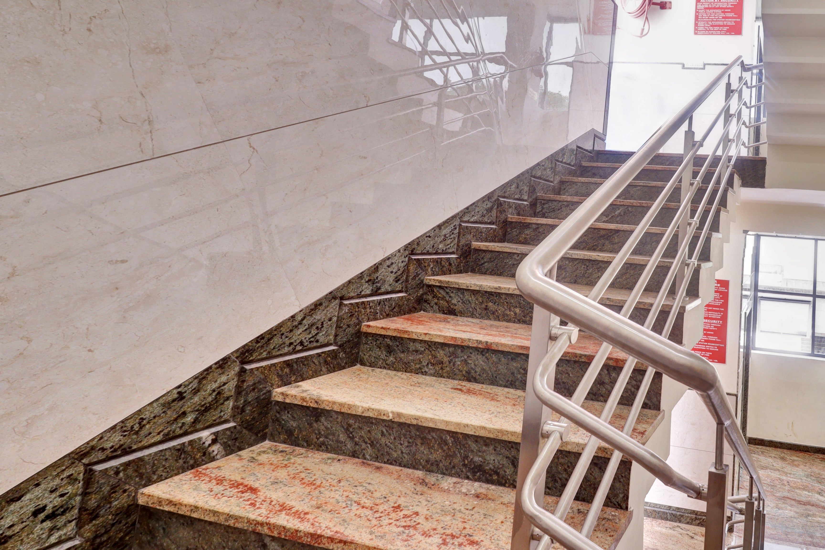 A staircase with marble steps and metal railings, leading to an upper floor.