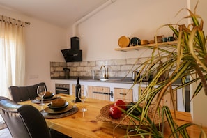 Ein Essbereich mit Holztisch, Stühlen und einer Küche im Hintergrund.
