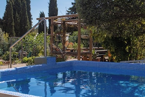 Une piscine dotée d’une terrasse en bois et d’une échelle en métal.