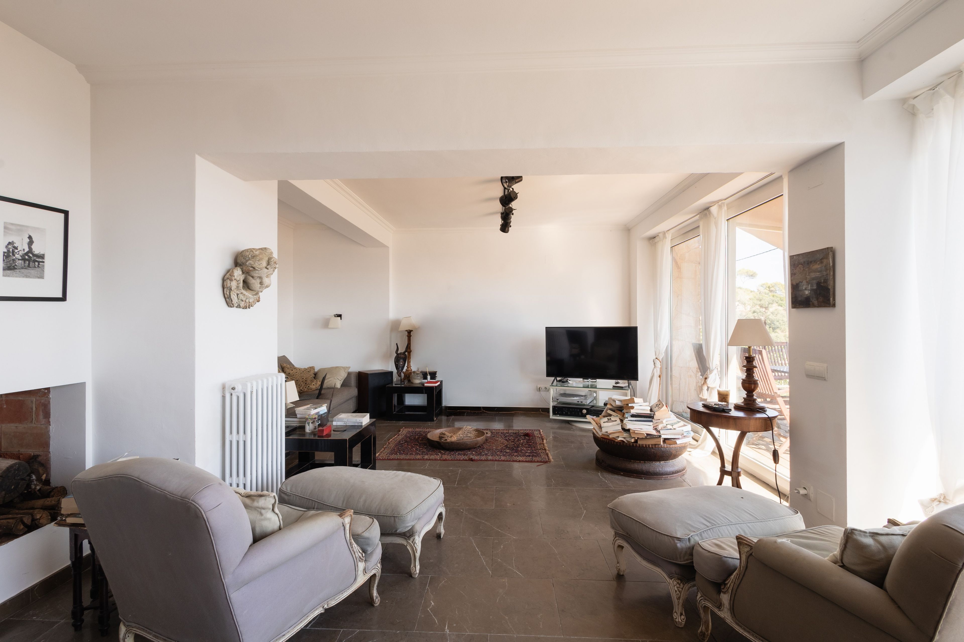A spacious living room with a fireplace, a television, and a large window.