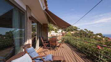 A wooden deck with outdoor furniture, a pergola, and a view of the landscape.