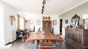 Un comedor con mesa de madera, sillas y un mueble con adornos.