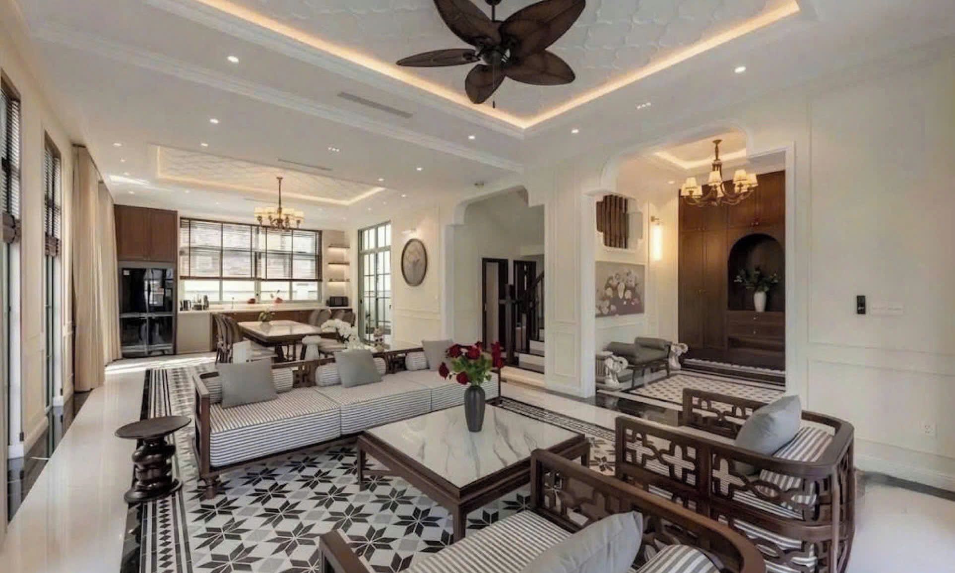 Un espacio habitable amplio con ventilador de techo alto, una zona de comedor con ventana grande y un rincón de estar acogedor con cojines estampados.