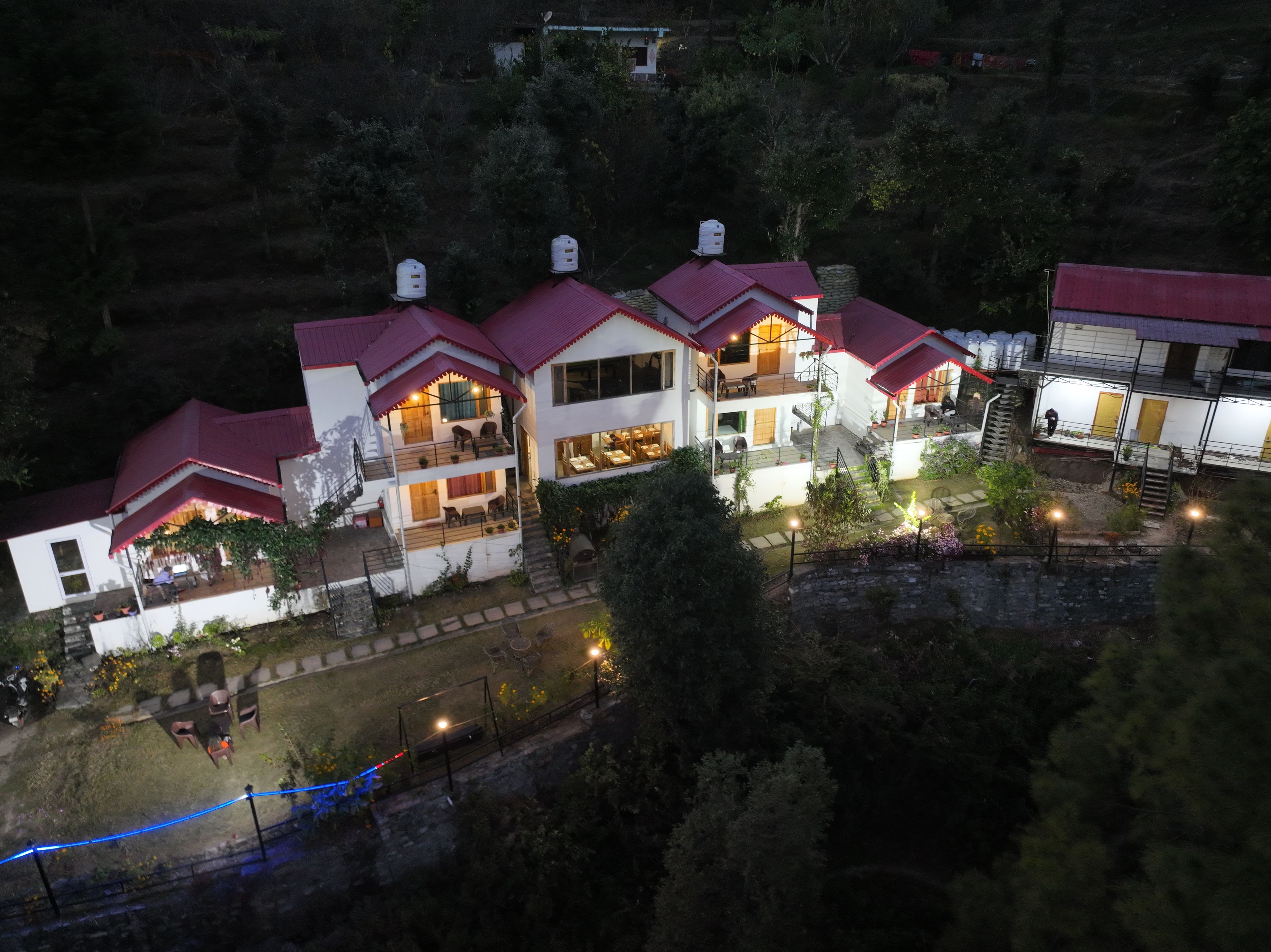 Un edificio de varios pisos con techo rojo, balcones y zonas de estar al aire libre.