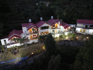 Un edificio de varios pisos con techo rojo, balcones y zonas de estar al aire libre.