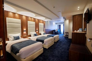 A hotel room with two beds, a desk, and a television. - Cecil Hotel - Ras Sedr (Ras Sudr)