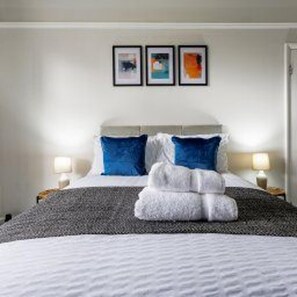 A hotel room with a bed, two pillows, a blanket, and a folded towel. There are two wall-mounted lamps on either side of the bed. - Darlington Town Centre - Stay 7 - Near Attractions (Darlington)