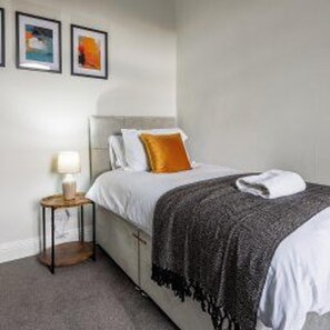 A bedroom with a bed, a bedside table, and a lamp. - Darlington Town Centre - Stay 7 - Near Attractions (Darlington)