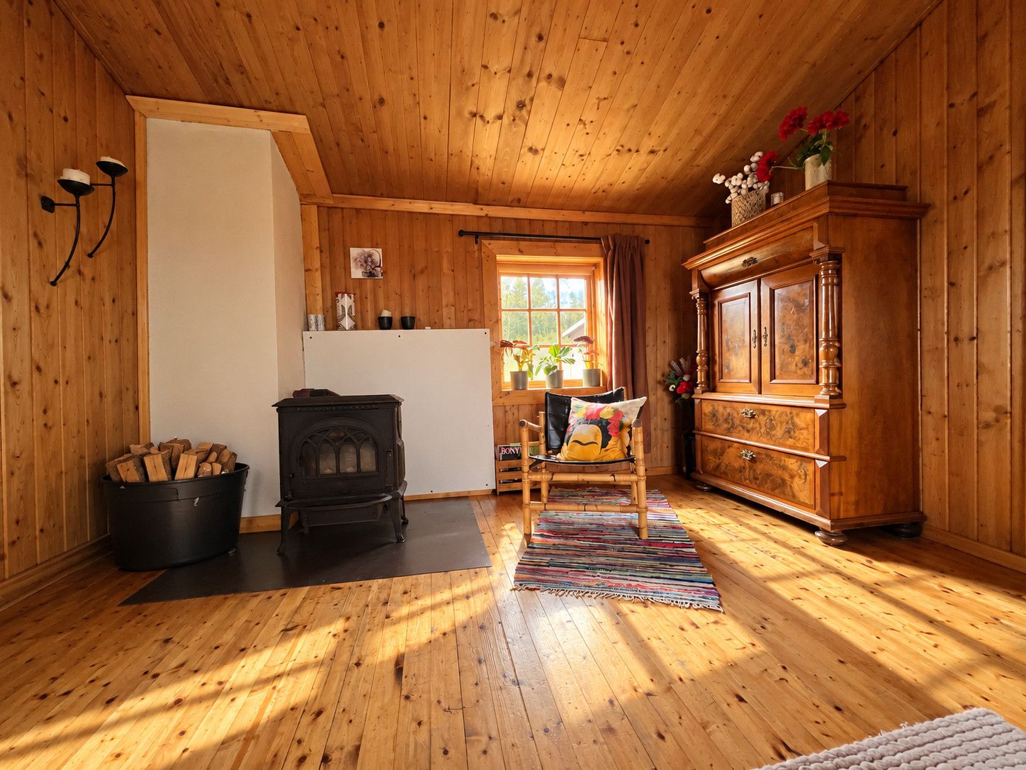 A wooden interior with a fireplace, a dining area, and a cabinet.