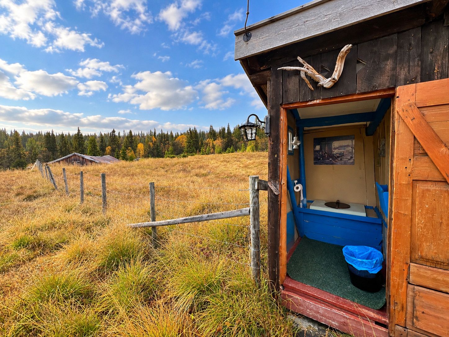A rustic wooden cabin with a single room featuring a toilet and a small window.