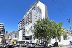 A multi-story building with a modern architectural design, featuring balconies and a clear sky. - Cape Town City 2Bed, Views, Balcony, Pool (Cape Town)