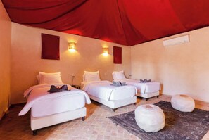 A hotel room with two beds, a red canopy, and a rug. - Atlas-view estate with staff, 20m pool and tennis (Marrakesh)