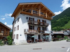 A two-story building with a cafe on the ground floor and a wooden balcony. - 250 meters from the ski lifts, 2nd floor, parking, TV, ski locker, 55 m², Arêches-Beaufort (Beaufort)
