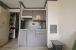 A compact kitchen with grey cabinets, a built-in oven, and a sink. - 130m from ski slopes, Ground floor, swimming pool, sauna, tv, ski locker, 25m², Alpe d'Huez (L'Alpe d'Huez)