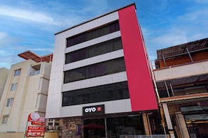 A hotel with a modern facade, featuring a prominent red vertical stripe and a sign for the OYO Hotel Paradise Inn. - Hotel O Paradise Inn (Bangalore)