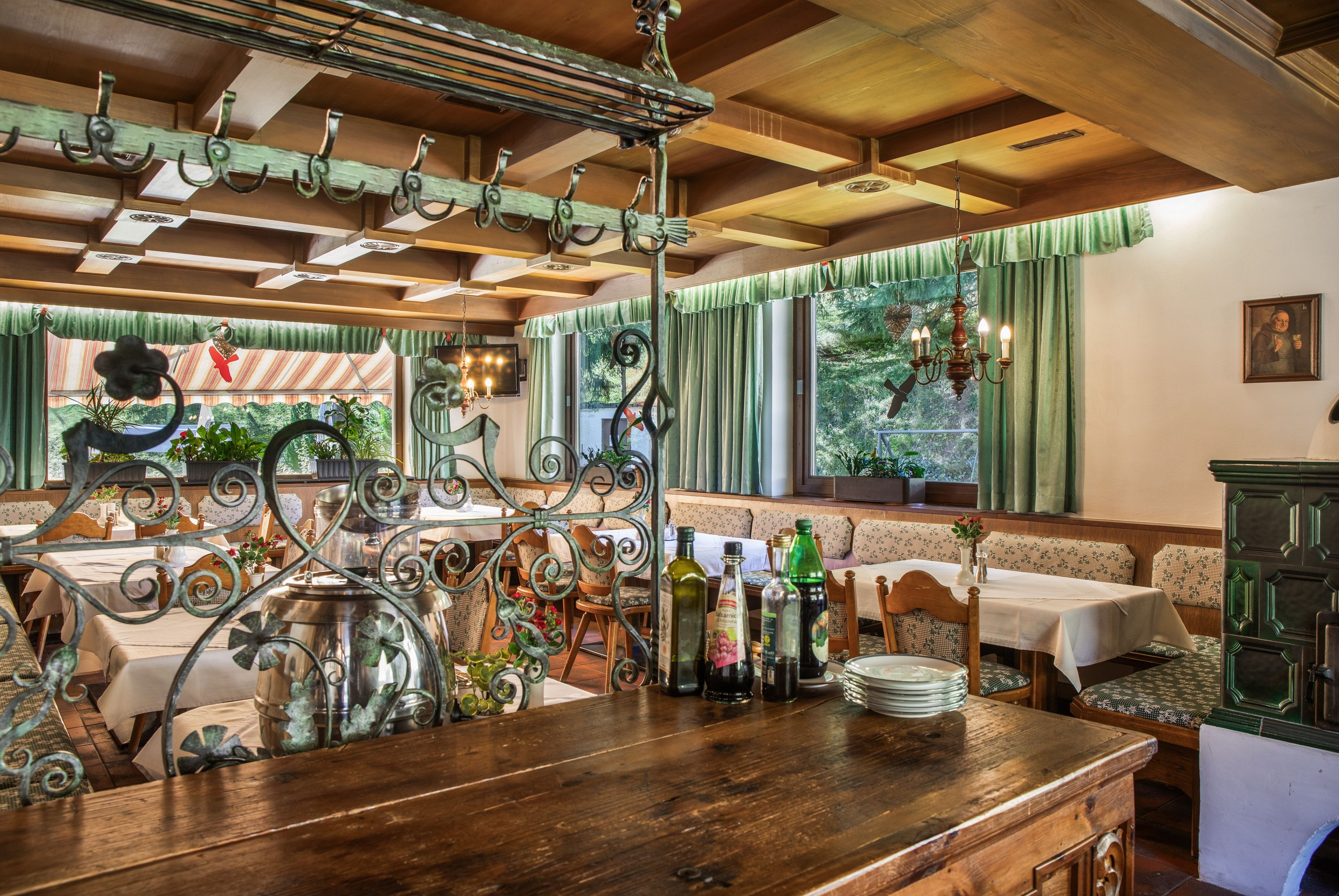 Ein Restaurantinneres mit Holztischen, einer Bar und Blick durch das Fenster.
