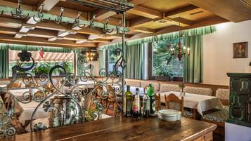 Ein Restaurantinneres mit Holztischen, einer Bar und Blick durch das Fenster.