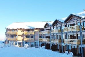 A multi-story hotel with balconies and a snow-covered roof. - Fitness, swimming pool, hammam, parking, tv, ski locker, 35m², Les Rousses (Prémanon)