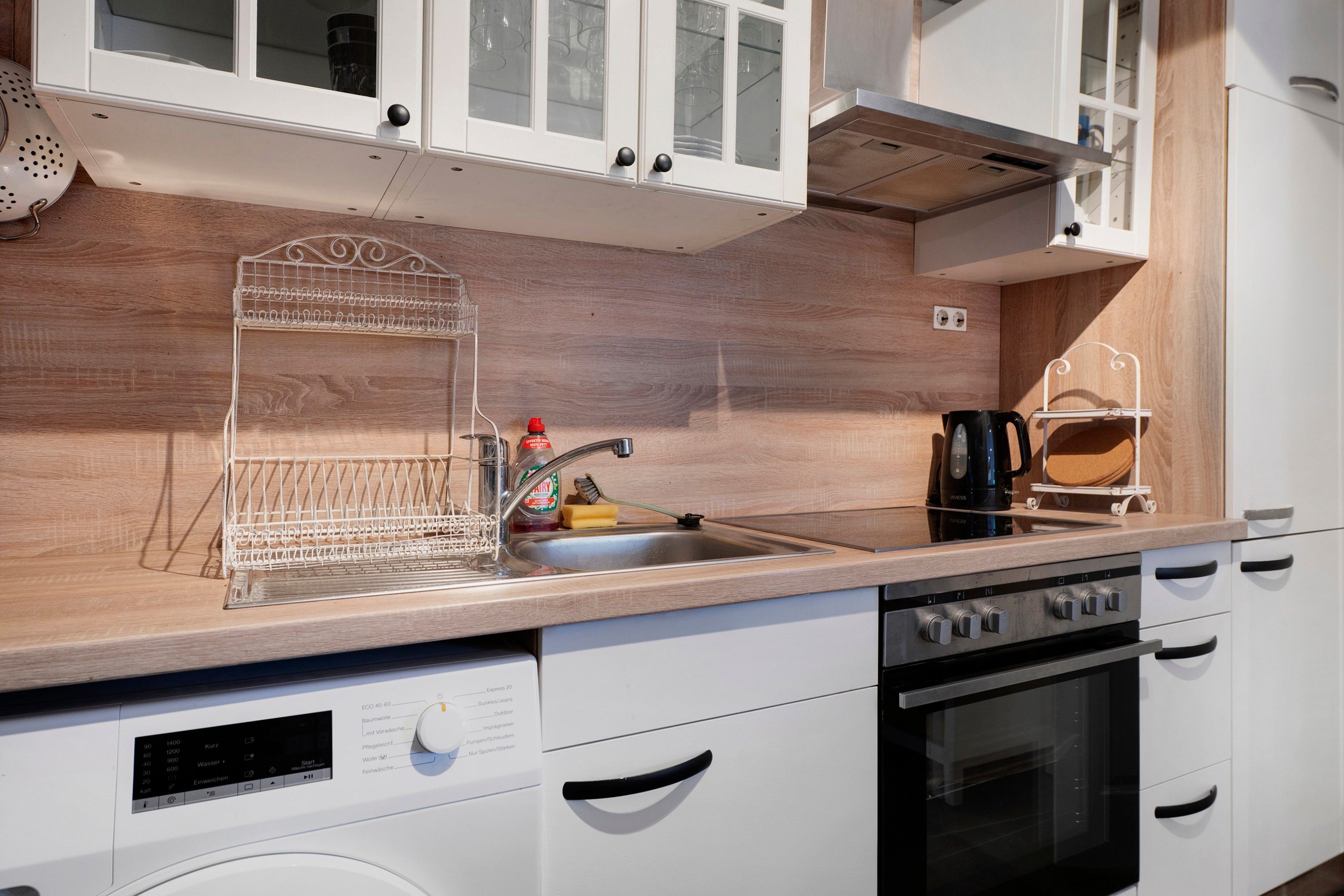 A modern kitchen with a built-in dishwasher, a stove, and a coffee maker.