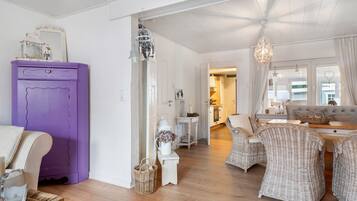 A room with a purple cabinet, wicker furniture, and a chandelier.