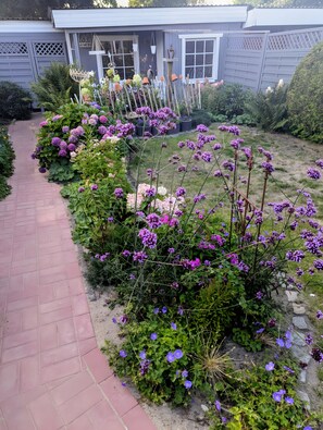 A garden pathway leading to a house with a grey facade and lattice window treatments. - Holiday Home 'Lilly' with Private Terrace, Private Garden and Wi-Fi (Meldorf)