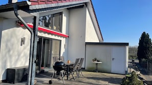 A patio with a grill, chairs, and a small table. - Pet-friendly vacation home just 10 minutes away from Safari Park & Bird Park (Böhme)