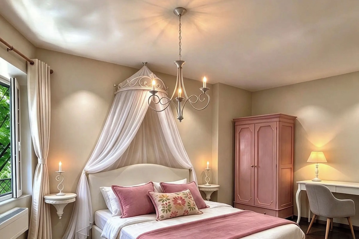 A bedroom with a canopy bed, bedside lamps, a desk, and a wardrobe.