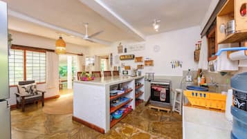 Una cocina amplia con una isla central, armarios de madera y piso de piedra.