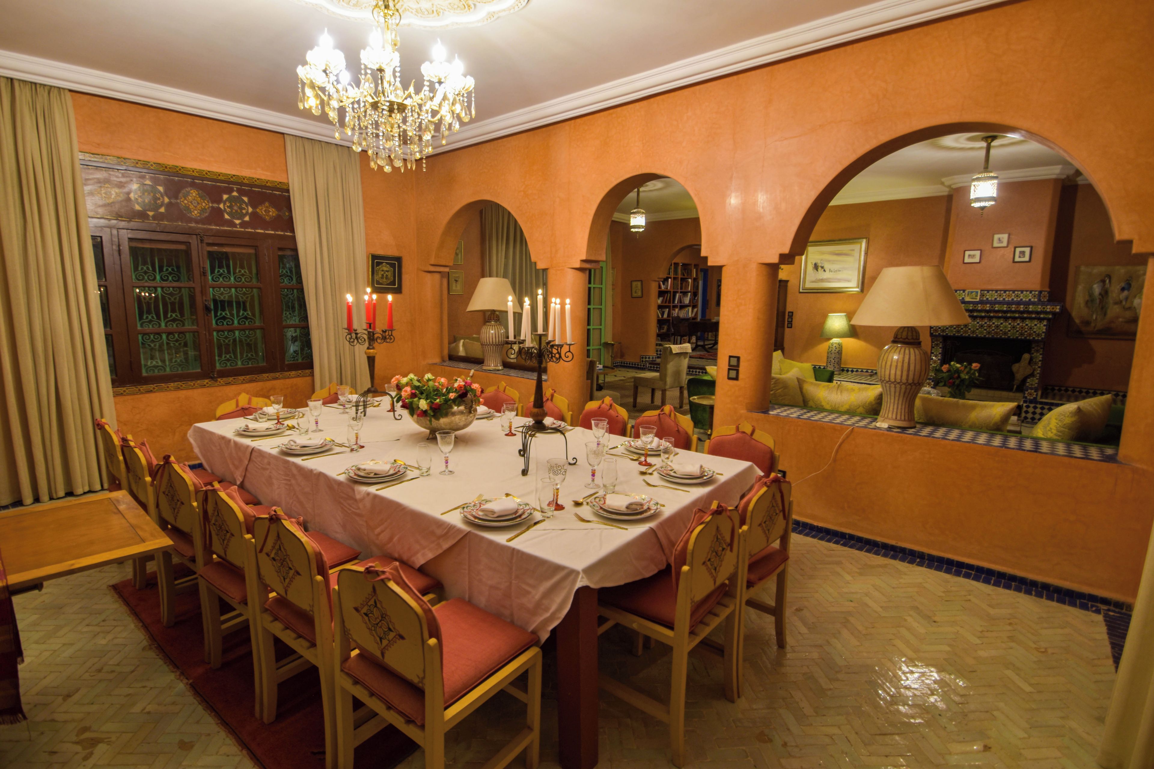 Un comedor con una gran mesa dispuesta para una comida, rodeada de sillas.