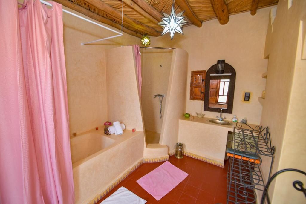 A bathroom with a shower, a sink, and a mirror.