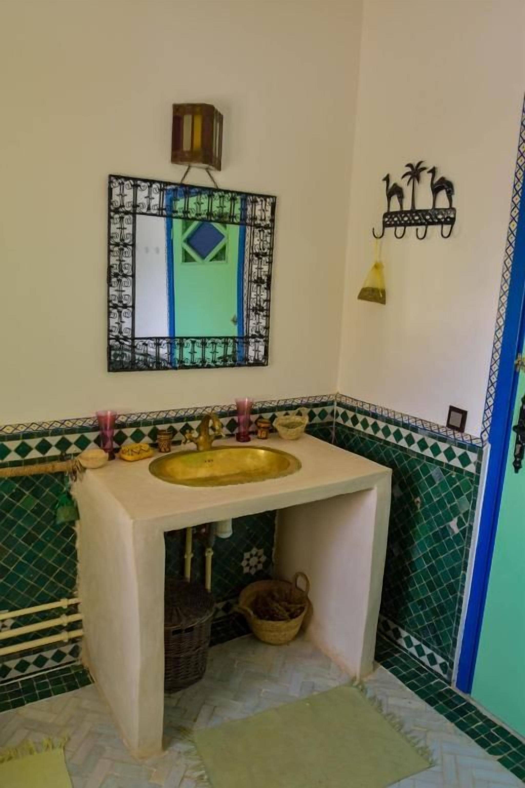 Un baño con lavamanos, espejo y un adorno en la pared.