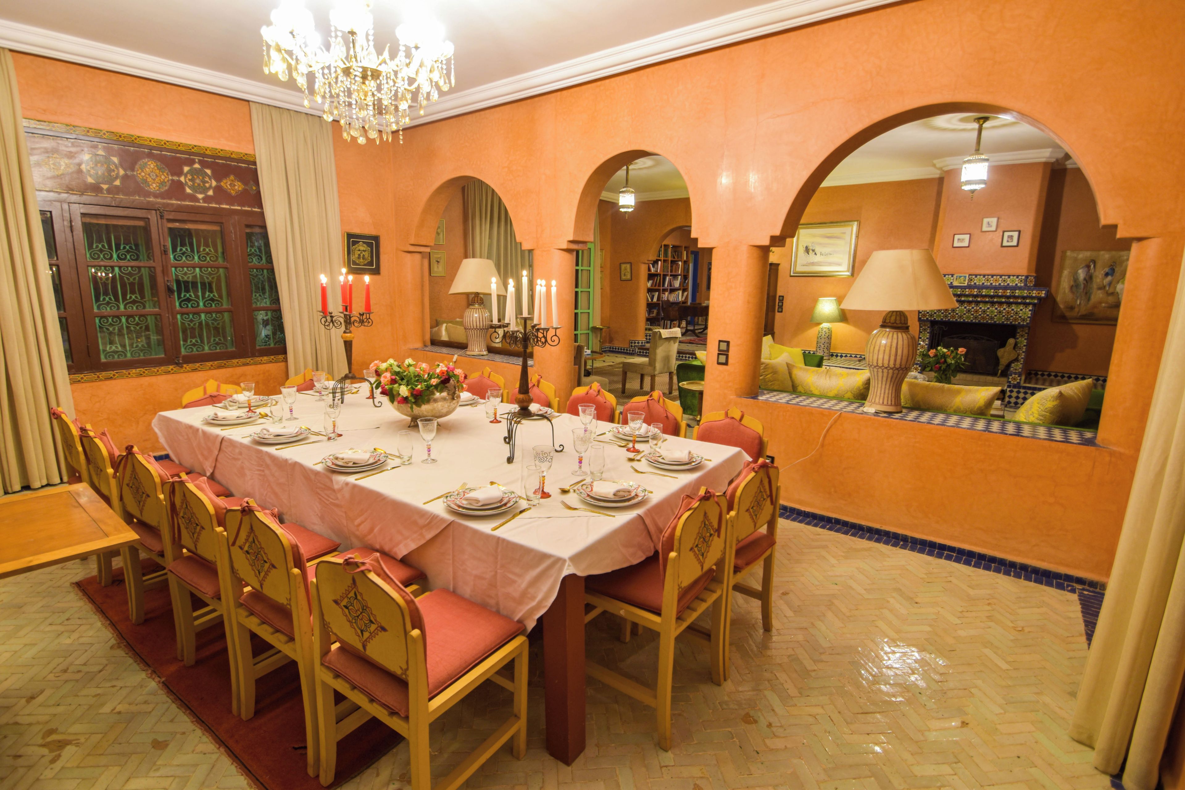 A dining room with a large table set for a meal, surrounded by chairs.