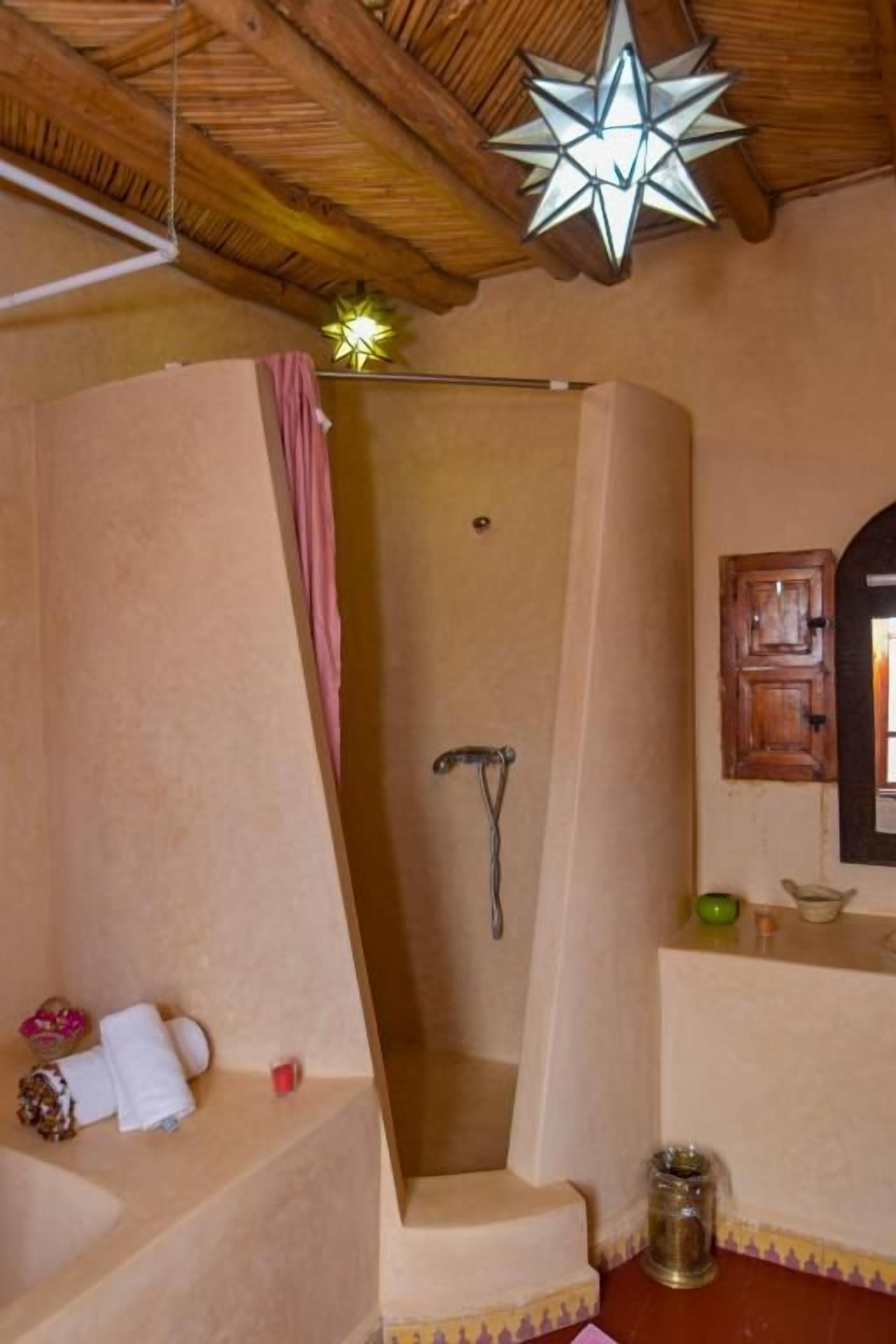 Ein Badezimmer mit Dusche, Waschbecken und Spiegel.