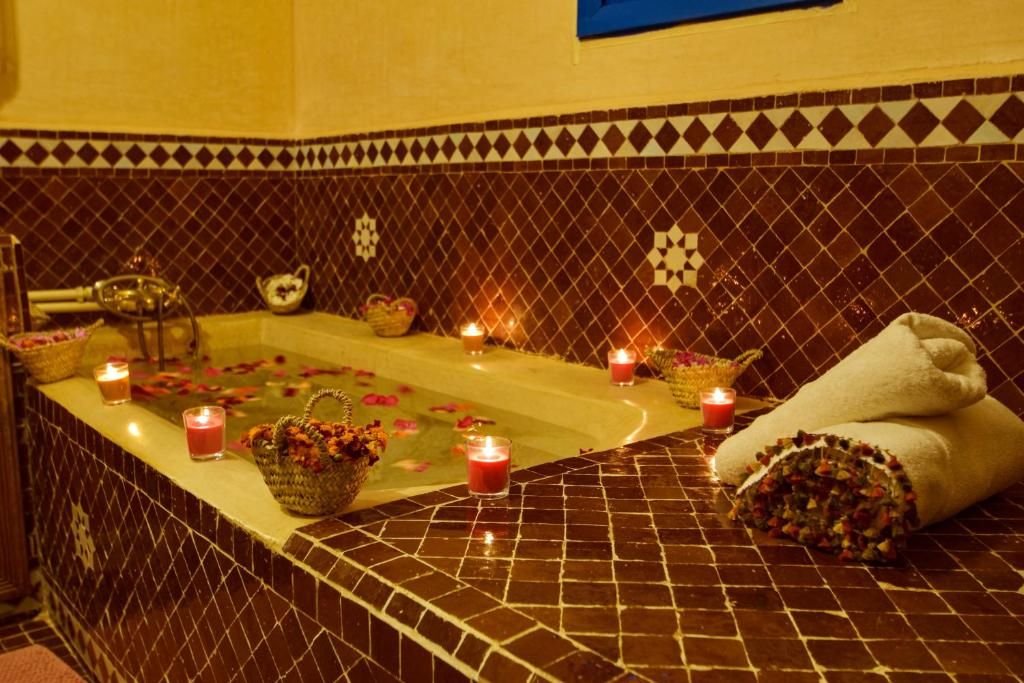 Un área de spa con bañera, velas y toallas.