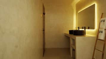 Une salle de bain avec un grand miroir, une échelle en bois et un lavabo doté d’un receveur noir.