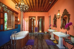 A bathroom with a freestanding bathtub, two sinks, ornate mirrors, and a chandelier. - Villa Sayang d'amour (Seminyak)