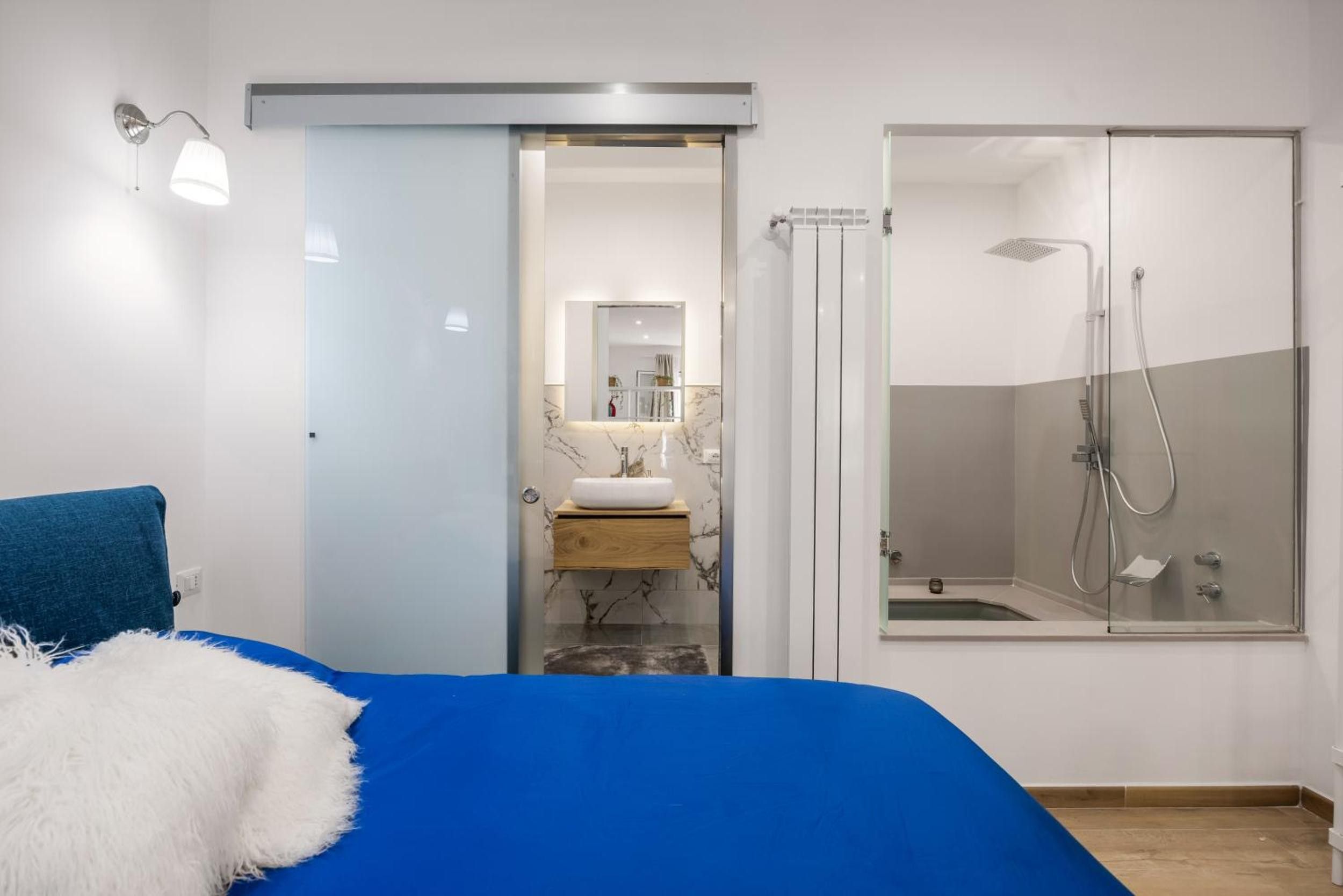 Ein Schlafzimmer mit einem Bett, einem Badezimmer mit Dusche und einem Spiegel.