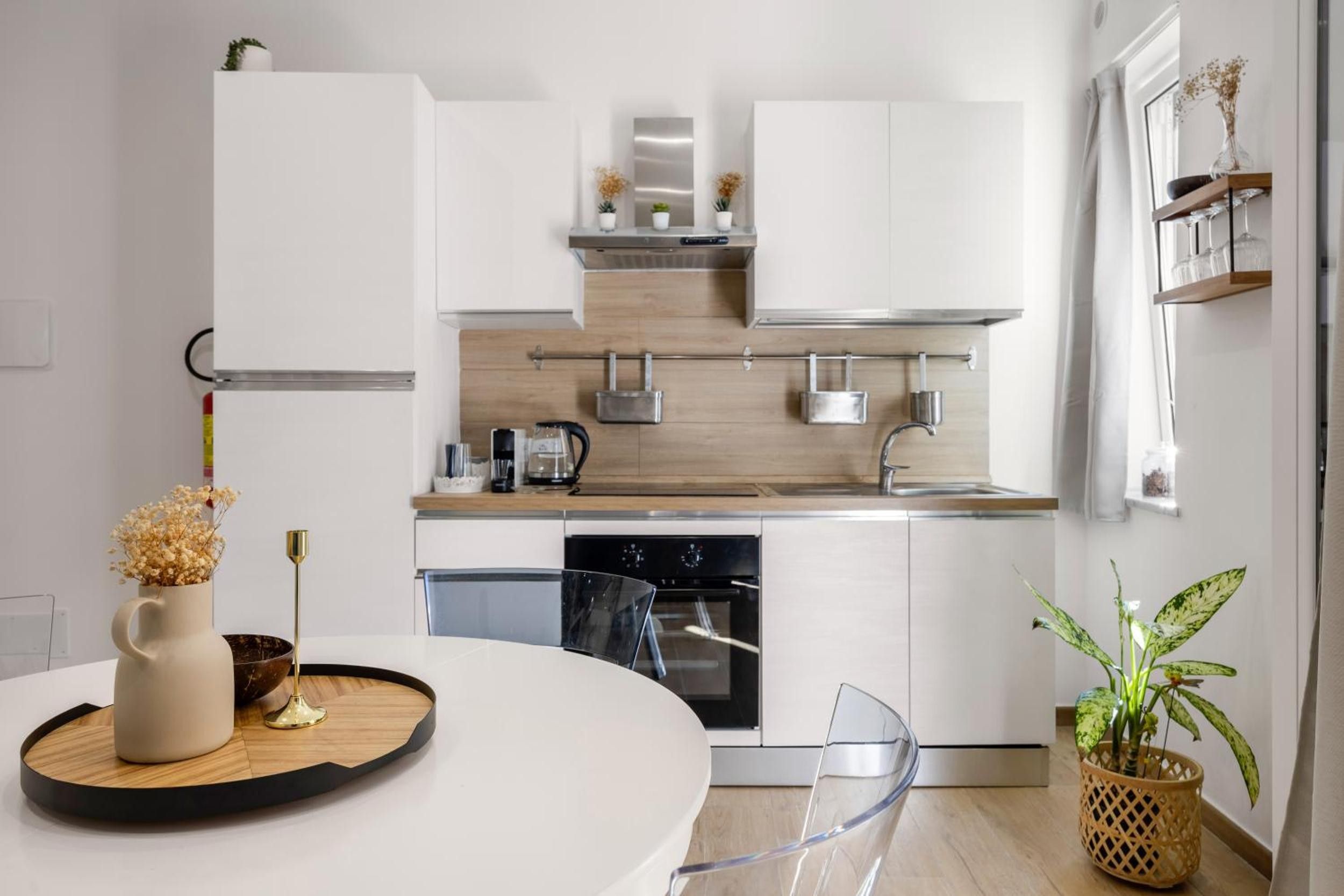 Eine moderne Küche mit weißen Schränken, einer Holz Arbeitsplatte und einem eingebauten Backofen.