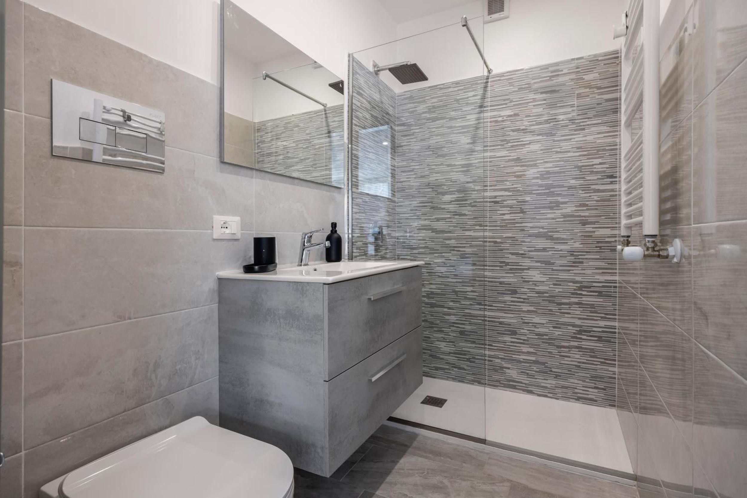 Une salle de bain moderne comprenant des toilettes, un meuble-lavabo et un espace douche.