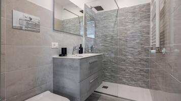 Une salle de bain moderne comprenant des toilettes, un meuble-lavabo et un espace douche.