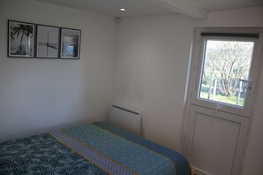 A bedroom with a bed, a window, and three framed pictures on the wall. - A lovely, bright one-bedroom apartment in a quiet location with a view of the garden. Perfect for a vacation. (Macau)