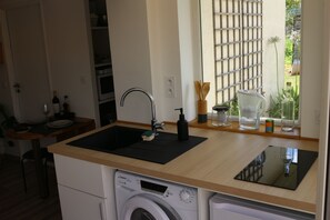 A kitchen with a built-in washing machine, a sink, and a window with a view of greenery. - A lovely, bright one-bedroom apartment in a quiet location with a view of the garden. Perfect for a vacation. (Macau)